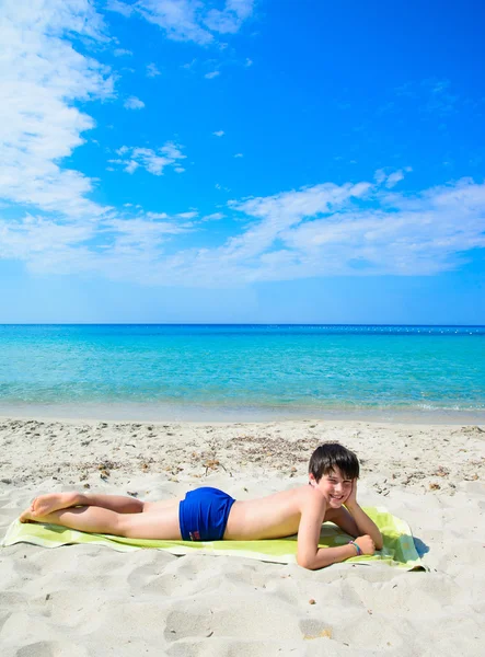 Garçon couché sur la plage tropicale — Photo