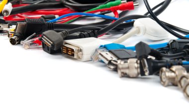 Birçok farklı bilgisayar kablosu ve fişi beyaza izole edilmiş.