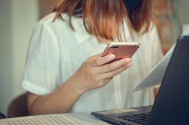 Bilgisayarlar, dijital tabletler ve cep telefonları kullanan modern cihazlarla çalışan iş kadınları, gerçekleştirilen işlerle temas halinde