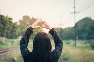 Kadınlar, sevgi ile el ele tutuşur. Sevgi dolu bir kalp şeklinde eller tarafından verilir..
