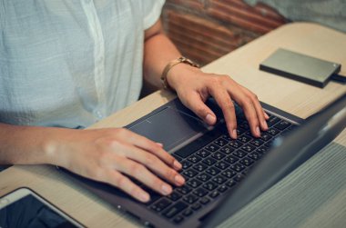 Bilgisayarlar, dijital tabletler ve cep telefonları kullanan modern cihazlarla çalışan iş kadınları, gerçekleştirilen işlerle temas halinde