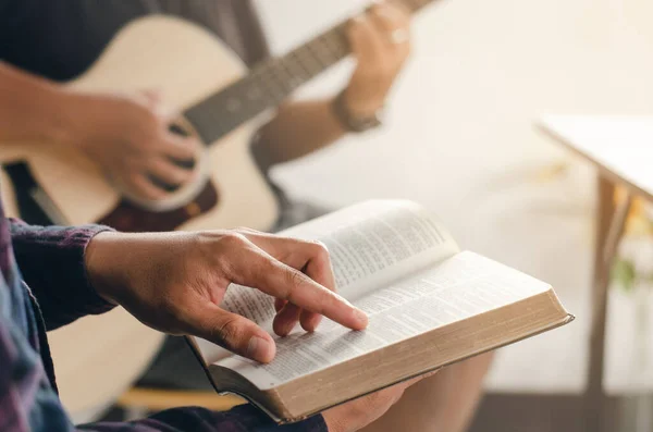 Young Boy Sat Read Bible While His Friend Played Guitar — Stockfoto
