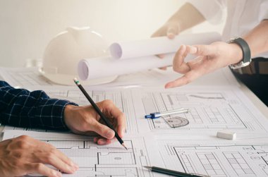 Mühendislerin planlarının yakından incelenmesi. Masada mimar teçhizatı mimarı başarılı takım çalışması konseptiyle