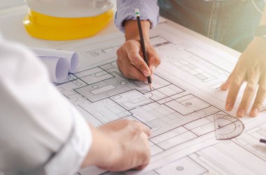 Mühendislerin planlarının yakından incelenmesi. Masada mimar teçhizatı mimarı başarılı takım çalışması konseptiyle