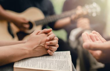 İncil 'li Hıristiyan dua grubu Tanrı' ya ibadet etmek için gitar çalıyor.