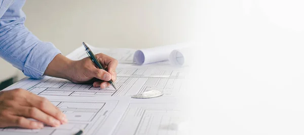 Close-up view of an engineer\'s plan drafting an architect\'s plan. along with the tools and equipment placed on the table Successful work concept