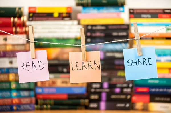 Post-it op string bevestigd met pinnen met boeken op achtergrond wazig — Stockfoto