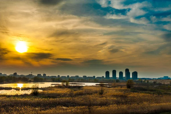 Écosystème de Bucarest Coucher de soleil sur l'écosystème aquatique du vieux lac Vacaresti avec de hauts bâtiments résidentiels gratte-ciel — Photo