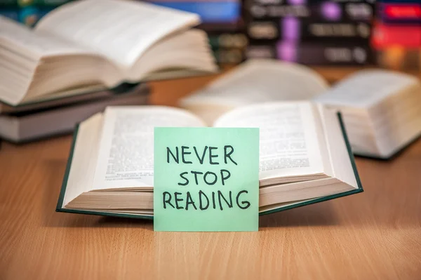 Open book with post it never stop reading message — Stock Photo, Image