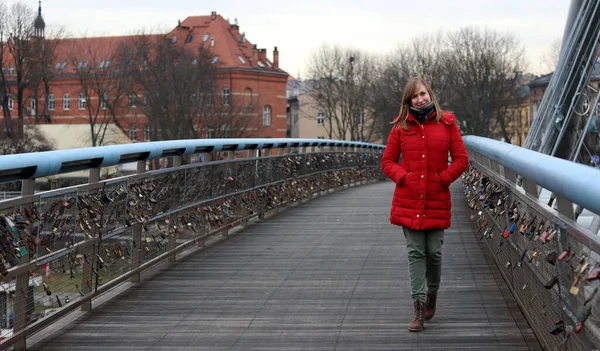 Kırmızı ceketli sarışın kadın ünlü Peder Bernatek 'in Aşk Köprüsü' nden geçiyor.