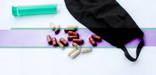 Yüz maskesi, şırınga ve haplar beyaz bir arkaplanda ve özel bir isim için yer var.