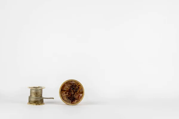 Lehim malzemeleri, beyaz arka planda teneke ve reçine. Hem kullanılmış hem kirli..