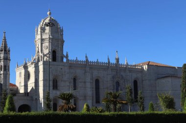 Architectural detail of the Jeronimos Monastery Mosteiro dos Jeronimos in Lisbon, Portugal. A UNESCO World Heritage site, this masterpiece of Manueline architecture features ornate stone carvings, a grand bell tower, and lush green gardens under a