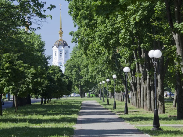 White bell tower with a gilded spire on blue sky background fram — ストック写真