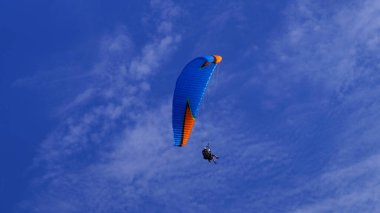 Paraglider üzerinde bir kişi gökyüzünde geziniyor.