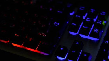 Klavyenin yakın çekimi bazı klavye karakterlerini odaklar. Pencerelerin klavyesine çok renkli arka plan ışığı odağı. Klavye İngilizce ve Rusça harfler