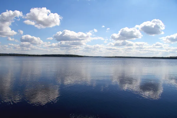 Nuvens refletidas em um lago — Fotografia de Stock