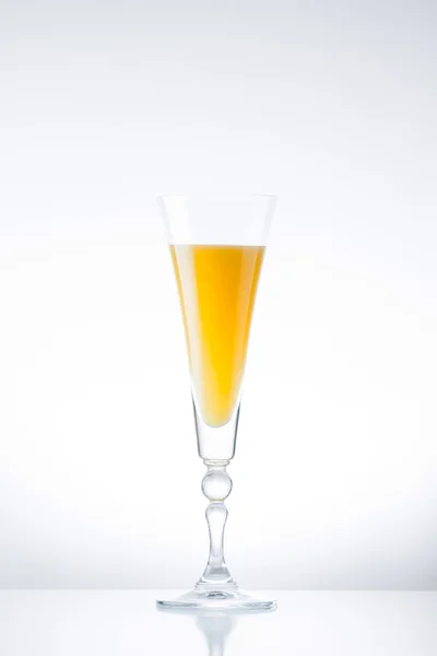 Pomerančová šťáva v skleničku na bílém pozadí — Stock fotografie