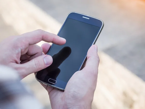 Primer plano de las manos del hombre sosteniendo y utilizando el teléfono inteligente móvil —  Fotos de Stock