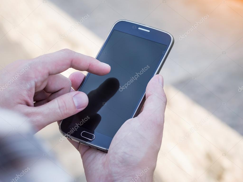 Close up of man's hands holding and using mobile smartphone