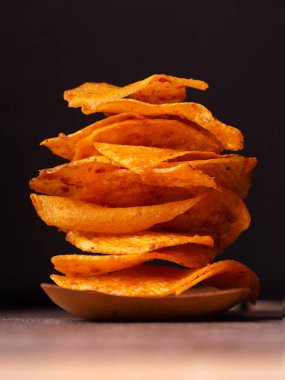 Siyah arkaplanda izole edilmiş patates cipsi yığını 