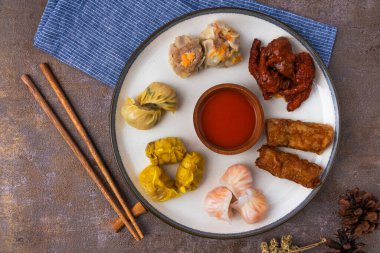 Seramik tabaklarda ve ahşap çubuklarda çeşitli Dim Sum çeşitleri