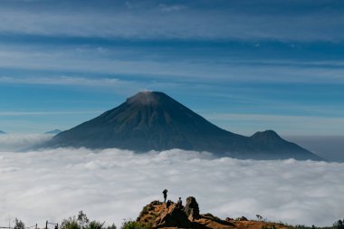 Merkezi Java Endonezya 'da sabah erken saatlerde bulutlardan oluşan dağların eteklerindeki köy manzarası
