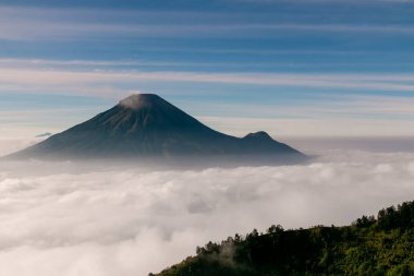 Sindoro dağlarının merkezi Java Endonezya 'daki bulutlar denizi sabah erkenden tepeden görünüyor.