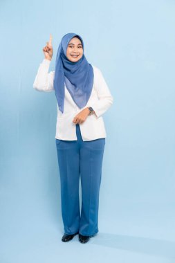 Mavi tesettürlü ve iş kıyafeti giyen genç bir Asyalı Müslüman önemli bir tavsiyeye işaret ediyor..
