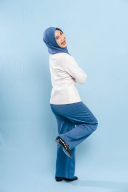 Genç Asyalı Müslüman bir kadının dinamik ve neşeli bir stüdyo portresi..