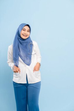 Kendinden emin ve gülümseyen Asyalı Müslüman bir doktorun ya da steteskoplu bir hemşirenin portresi..