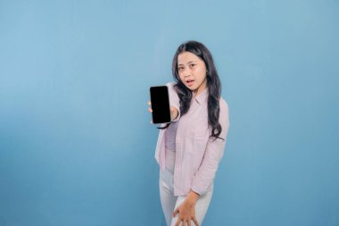 Bir kadın elinde cep telefonu ve bir yığın kitap tutuyor. Kadın cep telefonundan bilgileri göstermek istiyor.