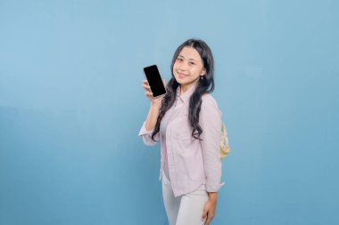 Bir kadın elinde cep telefonu ve bir yığın kitap tutuyor. Kadın cep telefonundan bilgileri göstermek istiyor.