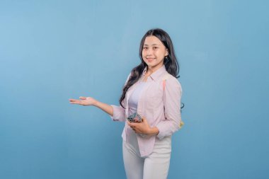 Bir kadın cep telefonunu tutar ve önemli bir şeye işaret eder. Gülümsüyor ve mutlu. Modern teknoloji ve iletişim kavramı