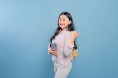 Bir kadın elinde bir tablet tutuyor ve onu işaret ediyor. Gülümsüyor ve mutlu.