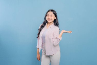 Bir kadın pembe gömlek ve beyaz pantolon giyerken bir şeyi işaret ediyor. Hedef gösterilen konu hakkındaki merak ve ilgi kavramı