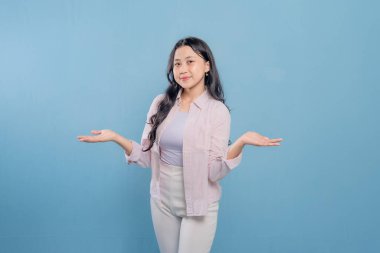 Bir kadın pembe gömlek ve beyaz pantolon giyerken bir şeyi işaret ediyor. Hedef gösterilen konu hakkındaki merak ve ilgi kavramı