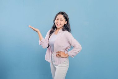 Bir kadın pembe gömlek ve beyaz pantolon giyerken bir şeyi işaret ediyor. Hedef gösterilen konu hakkındaki merak ve ilgi kavramı