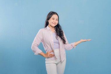 Bir kadın pembe gömlek ve beyaz pantolon giyerken bir şeyi işaret ediyor. Hedef gösterilen konu hakkındaki merak ve ilgi kavramı