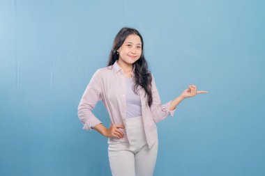 Bir kadın pembe gömlek ve beyaz pantolon giyerken bir şeyi işaret ediyor. Hedef gösterilen konu hakkındaki merak ve ilgi kavramı