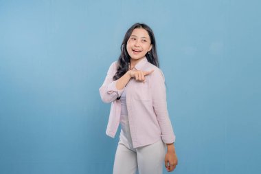 Bir kadın pembe gömlek ve beyaz pantolon giyerken bir şeyi işaret ediyor. Hedef gösterilen konu hakkındaki merak ve ilgi kavramı