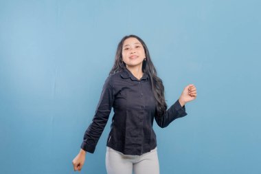 Siyah gömlekli bir kadın gülümsüyor ve kollarını havaya kaldırıyor. Sevinç ve kutlama kavramı