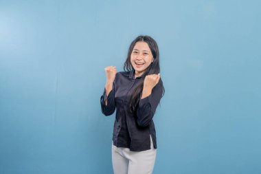 Siyah gömlekli bir kadın gülümsüyor ve kollarını havaya kaldırıyor. Sevinç ve kutlama kavramı