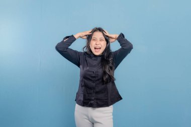 Siyah gömlekli bir kadın başını tutuyor ve gülüyor. Mizah anlayışı ve hafiflik.