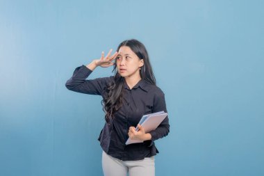 Bir kadın elinde kitap tutarken gökyüzüne bakıyor. Derin düşüncelere dalmış ya da bir şeyler düşünüyor.