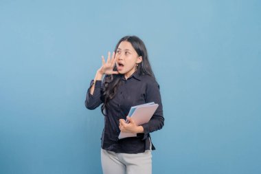 Siyah gömlekli bir kadın bir yığın kitap tutuyor ve yüksek sesle gürültü yapıyor. Hayal kırıklığı ya da sıkıntı kavramı