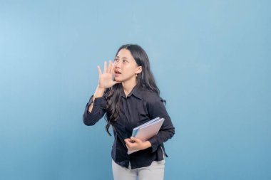 Siyah gömlekli bir kadın bir yığın kitap tutuyor ve yüksek sesle gürültü yapıyor. Hayal kırıklığı ya da sıkıntı kavramı