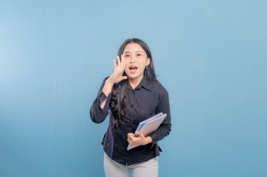 Siyah gömlekli bir kadın bir yığın kitap tutuyor ve yüksek sesle gürültü yapıyor. Hayal kırıklığı ya da sıkıntı kavramı