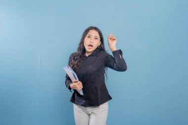 Bir kadın bir kitap tutuyor ve gülümsüyor. O mutlu ve heyecanlı. Neşe ve coşku kavramı