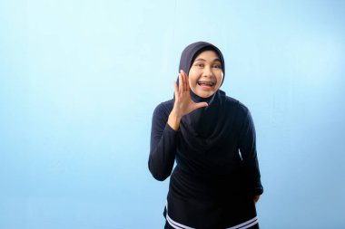 Siyah tesettürlü bir kadın elleriyle jest yapıyor. Bağırarak ya da bir şeyler söyleyerek bir jest yapıyor.